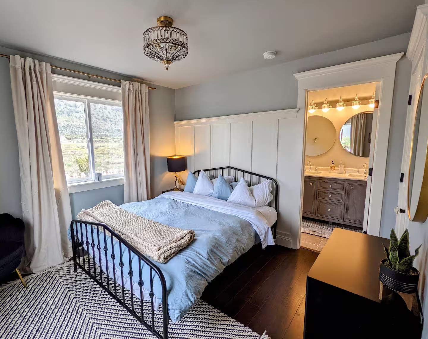 Bedroom with iron bed and ensuite bath