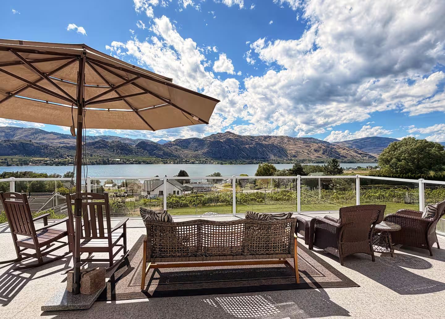 Covered deck with umbrella and seating overlooking Lake Osoyoos